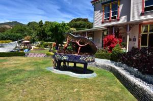 a grand piano, covered in bright mosaics, set in a lawn